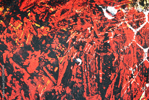 Thick red black and yellow paint in a scribbled abstract background
