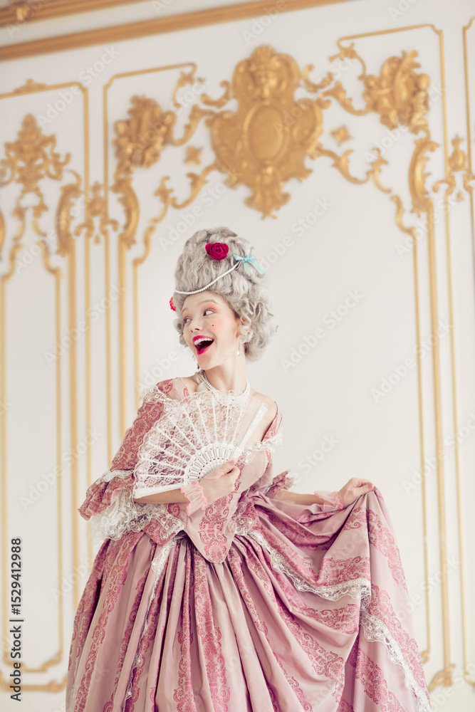 Fototapeta premium Elegant woman in a luxurious Victorian gown joyfully poses indoors, capturing the essence of historical aristocracy, vertical photo
