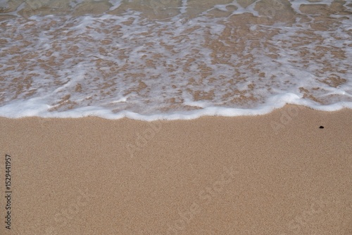 Fototapeta Naklejka Na Ścianę i Meble -  Beige sandy beach and sea waves with foams. Exotic sand beach with copy space