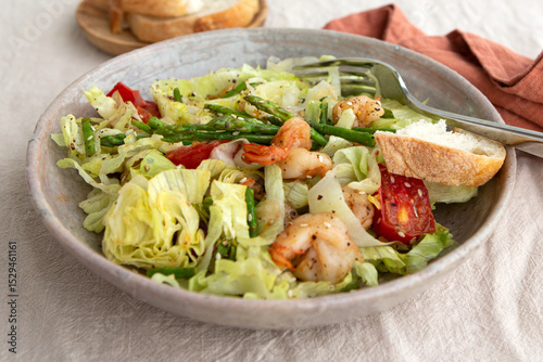 plate of salad with shrimp, asparagus and tomatoes on the table
