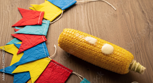 Buttered corn on the cob with colorful Festa Junina, são joão, flags on wooden background photo