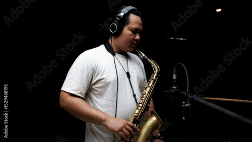 Musician Playing Saxophone in Recording Studio on dark black isolated background photo