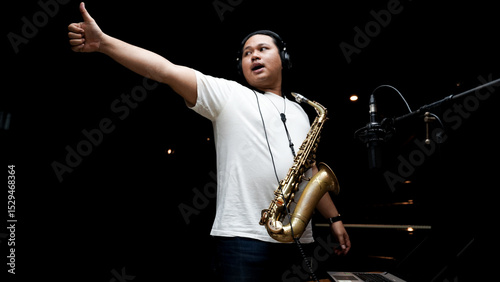 Musician Playing Saxophone in Recording Studio on dark black isolated background photo