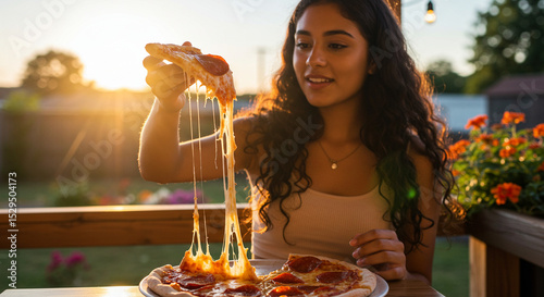 Medium shot of someone holding a slice of pepperoni pizza with cheese stretch