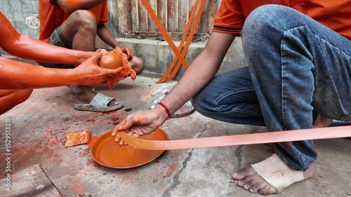 Make up of a devotee covered with orange at Lal Kach, Munshiganj, Bangladesh photo