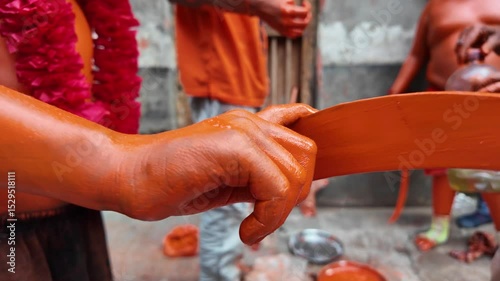 Make up of a devotee covered with orange at Lal Kach, Munshiganj, Bangladesh photo