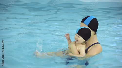 Mom teaches her daughter to swim in the pool. High quality 4k footage