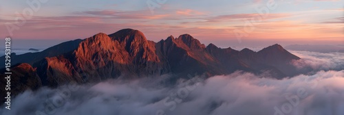 Jagged mountain ridge above dense cloud sea at sunrise