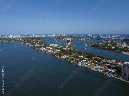 Daytime drone photo of Miami's Venetian Causeway with Biscayne Bay and city skyline under clear blue skies.