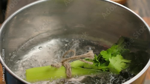 Adding a Bouquet Garni to Boiling Broth. Close-up. High quality 4k footage