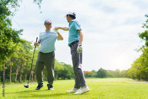 Asian man and elderly father are enjoy playing golf together with a good time.