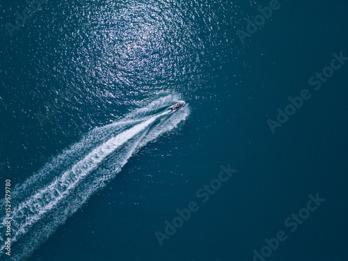 Wallpaper Mural Aerial view of a jet ski speeding across dark blue water, leaving a dynamic white trail. Captured by drone from above, showcasing motion, power, and summer fun on the sea Torontodigital.ca