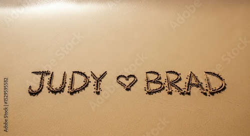 romantic beach message with “judy ♥ brad” written in the sand symbolizing love and togetherness