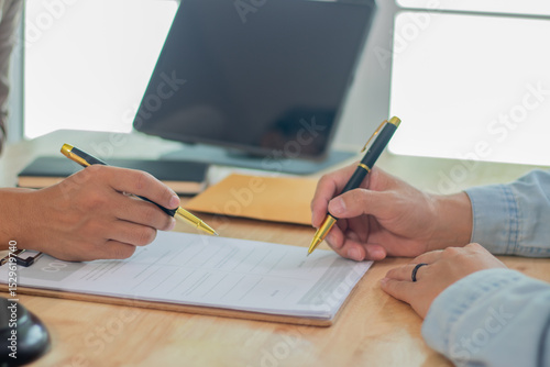Two experts, a businessman and a lawyer, are discussing legal documents in an office, reviewing contracts, strategies and investment laws during a planning meeting.