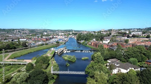 Exeter, Devon, England: DRONE VIEWS: Heading northwards over the River Exe, Trews suspension bridge and weir and onwards to the Quays. Exeter is a popular UK travel destination.