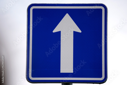 One-way traffic sign with a bold arrow indicating direction. A clear symbol of regulated street flow, helping ensure safe and organized movement in urban and road environments.

