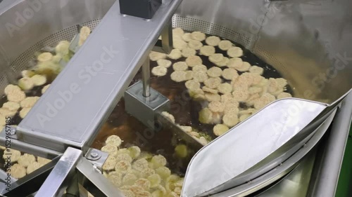 Rice crackers are fried to golden perfection in a high-speed automatic fryer, ensuring crispiness and efficiency.