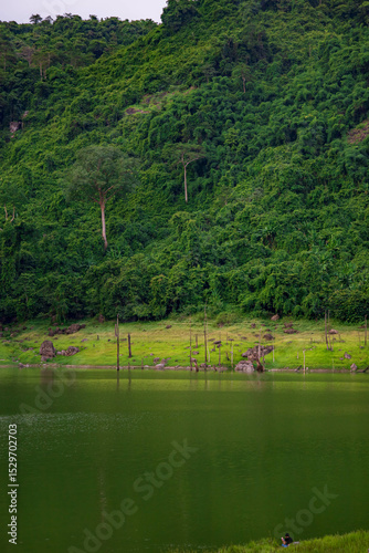 Beautiful landscape of a peaceful mountain, lake  in the dam reflecting the green forest and cloudy sky.