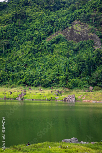 Beautiful landscape of a peaceful mountain, lake  in the dam reflecting the green forest and cloudy sky.