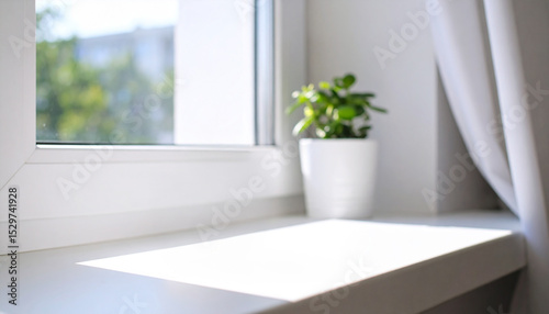 Sunlight shining through window and white curtains illuminating window sill