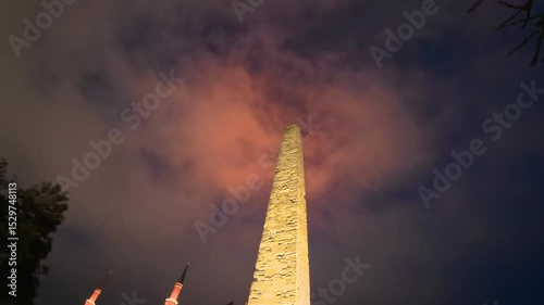 The Obelisk of Theodosius illuminated at night with the Blue Mosque minarets glowing in the background, creating a dramatic scene in Sultanahmet, Istanbul.
 photo