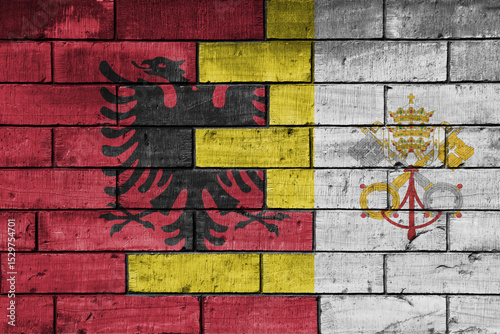 colourful painted big national flag of vatican city and flag of albania on a massive old brick wall background. concept