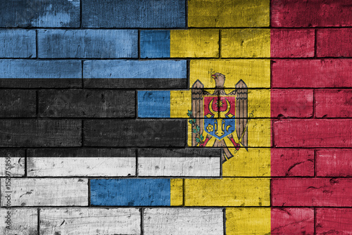 colourful painted big national flag of moldova and flag of estonia on a massive old brick wall background. concept