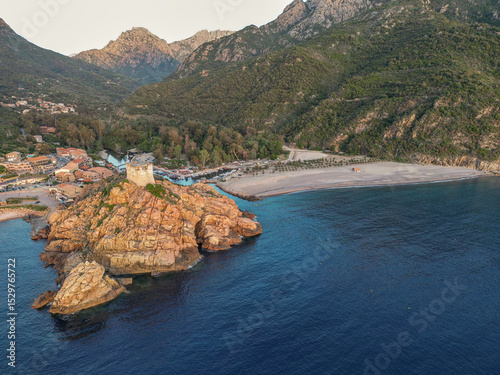 Aerial view town ruins Genoese tower of Porto Corsica France medieval watchtower Mediterranean Sea Calanches de Piana photo