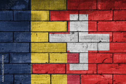 colourful painted big national flag of switzerland and flag of romania on a massive old brick wall background. concept