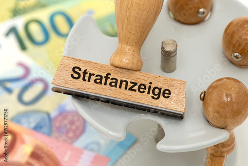 Ein Holzstempel ist beschriftet mit dem Aufdruck Strafanzeige