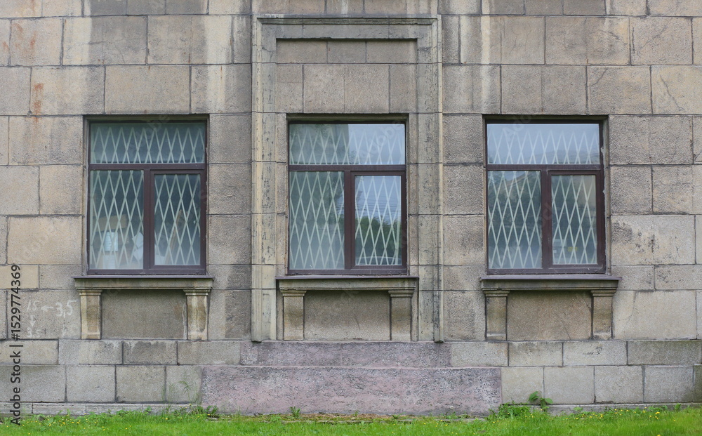 Three windows of an old house with bars inside Three windows of an old house with bars inside