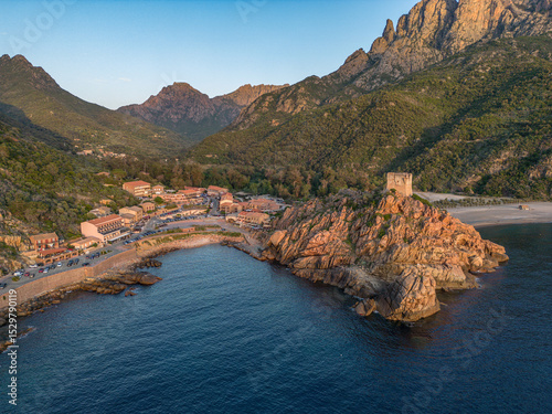 Aerial view town ruins Genoese tower of Porto Corsica France medieval watchtower Mediterranean Sea Calanches de Piana