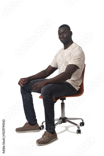 full portrait of a man sitting on chair looking at camera on white background