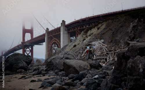 The Golden Gate Bridge in San Francisco, California disappears into the fog, as seen from the beach.