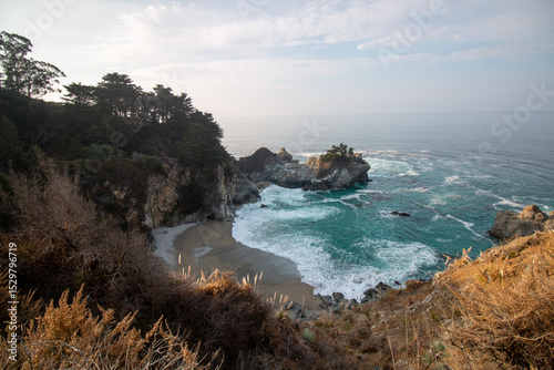 Iconic McWay Falls Cascading onto a Secluded Beach in a Turquoise Cove at Sunset in Big Sur, California
