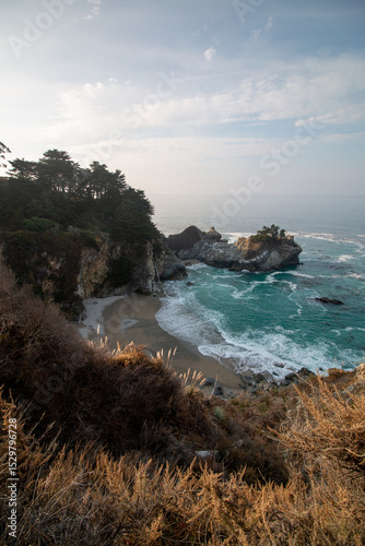 Iconic McWay Falls Cascading onto a Secluded Beach in a Turquoise Cove at Sunset in Big Sur, California