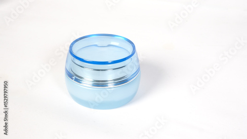 a sleek light blue cosmetic jar with a glossy finish on white background