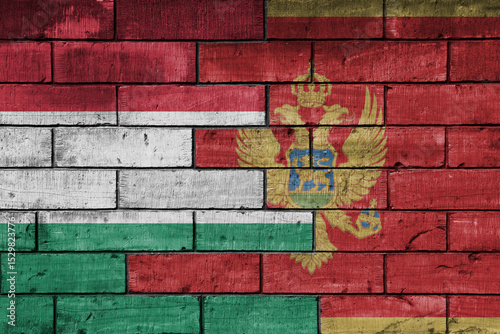 colourful painted big national flag of montenegro and flag of hungary on a massive old brick wall background. concept