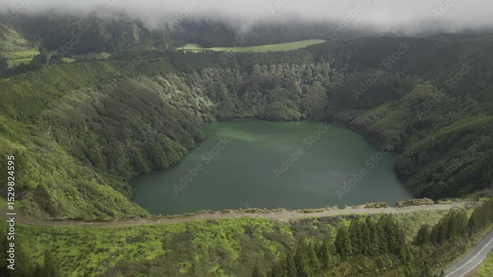 Drone flies east over Miradouro da Lagoa de Santiago toward Santiago Lake in Sete Cidades, Sao Miguel, Azores, Portugal