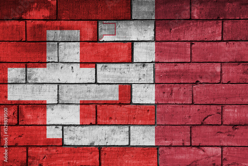 colourful painted big national flag of malta and flag of switzerland on a massive old brick wall background. concept