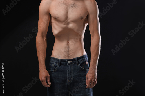 Man suffering from anorexia on black background, closeup