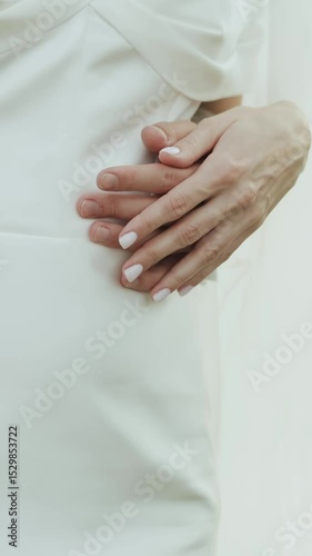 A tender moment between the bride and groom, the bride's hand delicately touching the groom's hand. Vertical video.