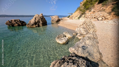 Fototapeta Naklejka Na Ścianę i Meble -  beautiful coastal landscape sunrise scenery, natural rock formations at sandy beach, with mountain Biokovo in background, Mimice, Dalmatia, Croatia, Adriatic sea at Mediterranean