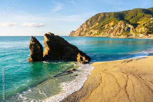 Fototapeta Naklejka Na Ścianę i Meble -  Coastal village Monterosso al Mare glows under summer sun in Cinque Terre National Park, Liguria, Italy. Ligurian sea in summer time. Landscape photography