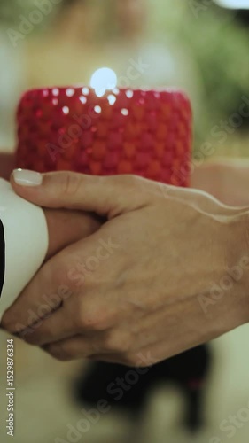 Close up shot of a Beautiful and Romantic Candlelit Moment in the wedding Featuring Intertwined Hands in Affectionate Connection. Vertical video