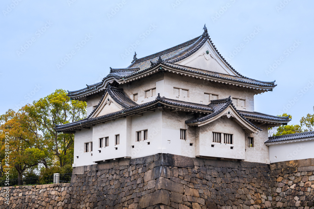 Fototapeta premium Osaka Castle with the beautiful lake surrounding it during Spring and the cherry blossoms , Osaka, Japan, South East Asia.