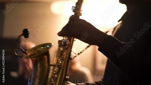 Musician playing the saxophone with warm, ambient lighting against a blurred background