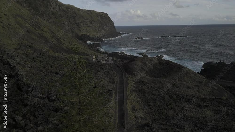 Drone flies south along coast at Ponta da Ferraria and over a natural thermal pool by the ocean in Sete Cidades region, Sao Miguel, Azores, Portugal