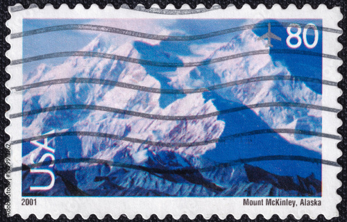 U.S. airmail stamp depicting Mount McKinley (now Denali), the tallest peak in North America, located in Alaska. Issued in 2001. A majestic snowy landscape photo