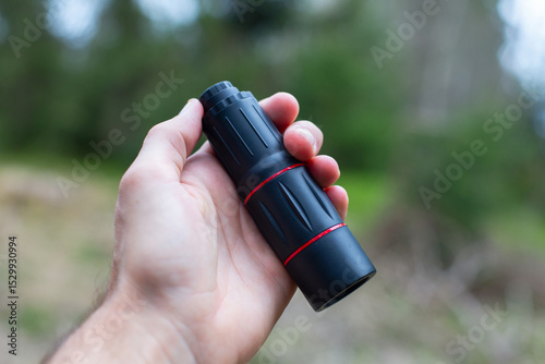 monocular in a hand in the forest